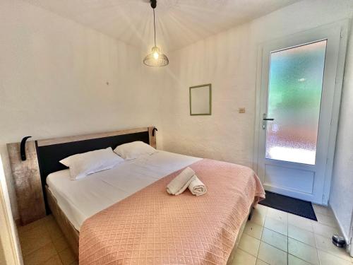 une chambre avec un lit avec une serviette dessus dans l'établissement Mini-villa 2 pièces 4 couchages à 5 min de la plage de Pinarello, à Olmucciu