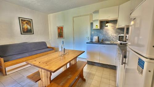 - une cuisine avec une table et un canapé dans une chambre dans l'établissement Mini-villa 2 pièces 4 couchages à 5 min de la plage de Pinarello, à Olmucciu