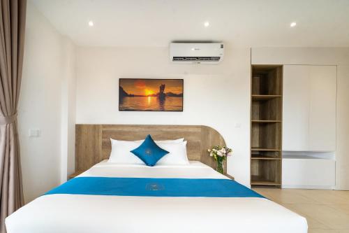 a bedroom with a bed with blue and white sheets at Novus Sol Hotel & Apartment Sunset Town Phu Quoc in Phu Quoc