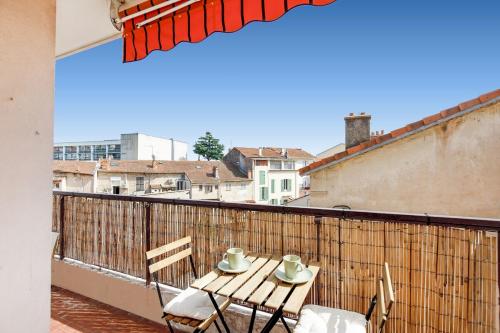 une table et des chaises assises sur un balcon dans l'établissement Nice Flat with terrace & parking near city center, à Cannes