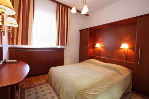 a bedroom with a bed and a table and two lamps at Kazakhstan Express in Almaty