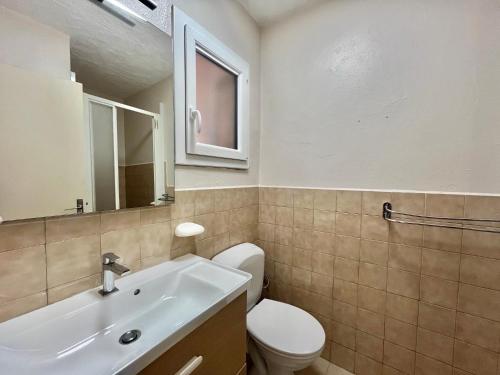 une salle de bain avec des toilettes blanches et un lavabo dans l'établissement Mini-villa 2 pièces 4 couchages à 5 min de la plage de Pinarello, à Olmucciu