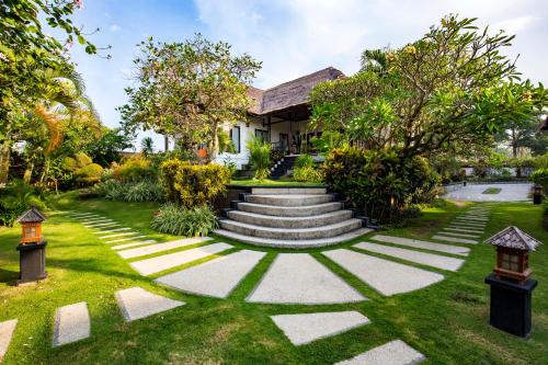 a house with a garden with stairs and trees at Villa L'Orange Bali in Keramas