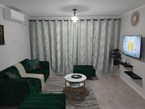 a living room with a green couch and a table at Motswedi Place-Lola B12 in Gaborone