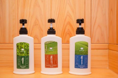three bottles sitting on top of a wooden table at 風香る森のホテル鈴桃rindou in Shizuoka
