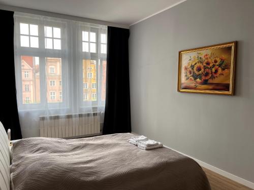 a bedroom with a bed and a painting on the wall at Long Island in Grudziądz