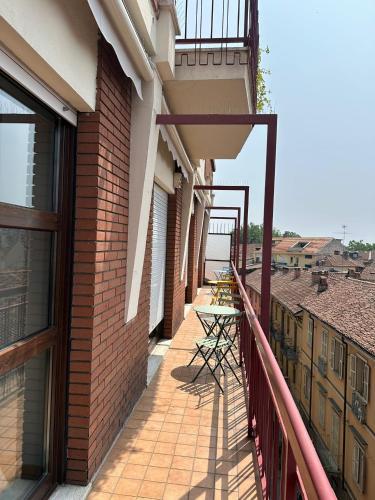 a balcony with a table and chairs on a building at Cà Vascello- Terrazza panoramica in centro in Asti
