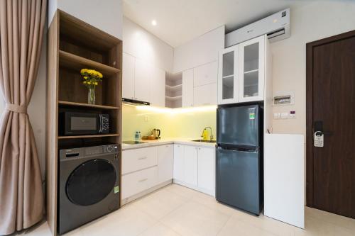 a kitchen with a refrigerator and a washer and dryer at Novus Sol Hotel & Apartment Sunset Town Phu Quoc in Phu Quoc