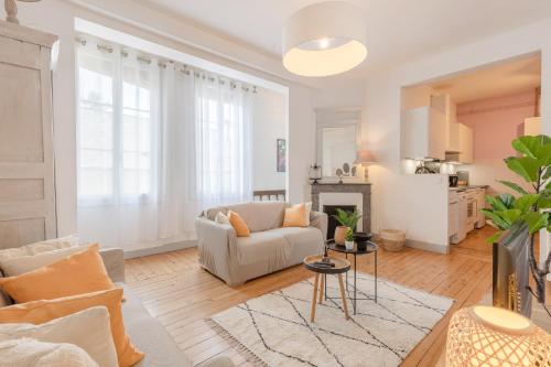 a living room with a couch and a fireplace at Le Monnaie - Appartement lumineux face au Château de Pau in Pau