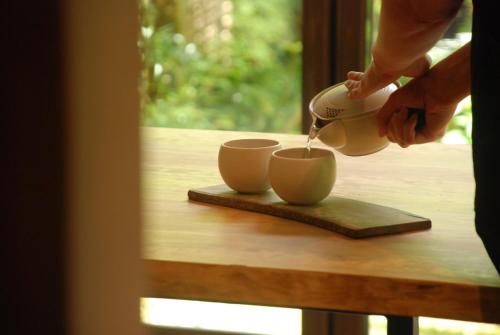 a person pouring coffee into cups on a table at 風香る森のホテル鈴桃rindou in Shizuoka