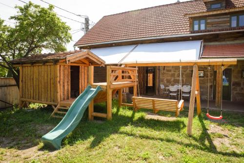 a playground with a slide in front of a house at Válaszút Fogadó in Păuleni-Ciuc
