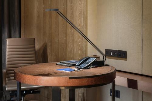 a desk with a remote control and a lamp on it at Hilton Shenzhen Shekou Nanhai in Shenzhen