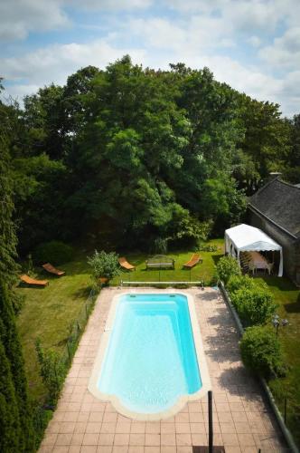 - une vue sur la piscine dans la cour dans l'établissement Villa en campagne à Langoëlan - Piscine privée, à Langoëlan