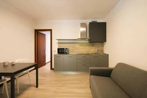 Una sala de estar con un sofá y una cocina. en Nogarazza, en Arcugnano
