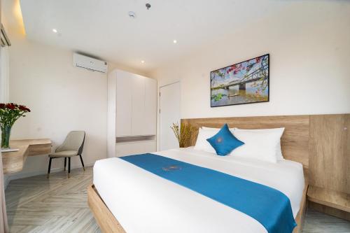 a hotel room with a bed and a desk at Novus Sol Hotel & Apartment Sunset Town Phu Quoc in Phu Quoc