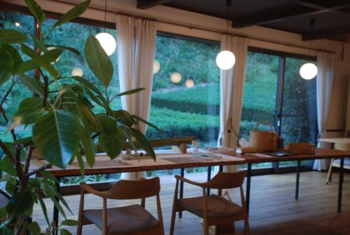 a dining room with a table and a potted plant at 風香る森のホテル鈴桃rindou in Shizuoka
