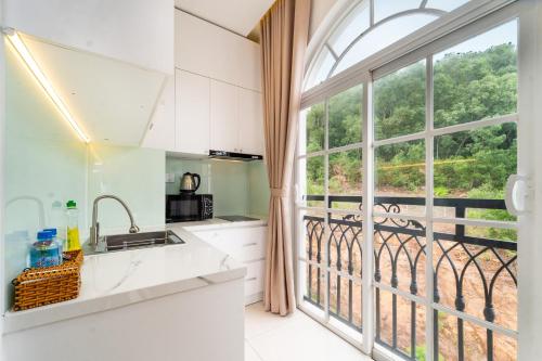 a kitchen with a large window with a view of a balcony at Novus Sol Hotel & Apartment Sunset Town Phu Quoc in Phu Quoc