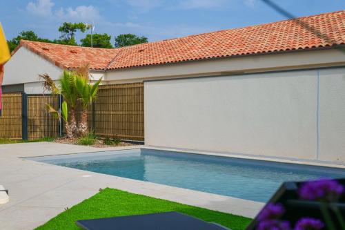 une piscine devant une maison dans l'établissement Villa des Hérondais avec piscine - idéal familles - 8 personnes, à Jard-sur-Mer