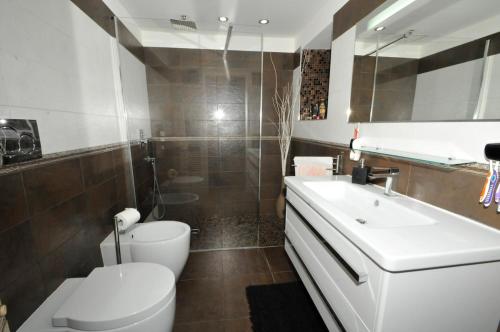 a bathroom with a white toilet and a sink at Monica & Rocco's House in Venaria Reale