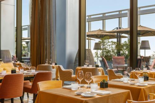 a restaurant with tables and chairs and windows at Bvlgari Hotel Tokyo in Tokyo
