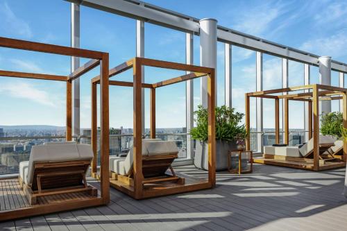 a balcony with three chairs on a building with windows at Bvlgari Hotel Tokyo in Tokyo