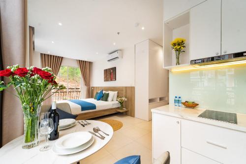 a kitchen and living room with a bed and a table at Novus Sol Hotel & Apartment Sunset Town Phu Quoc in Phu Quoc