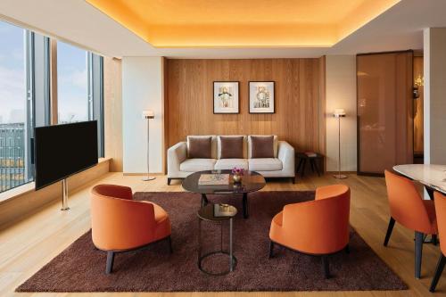 a living room with a couch and a table and chairs at Bvlgari Hotel Tokyo in Tokyo