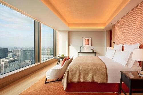 a bedroom with a large bed and a large window at Bvlgari Hotel Tokyo in Tokyo