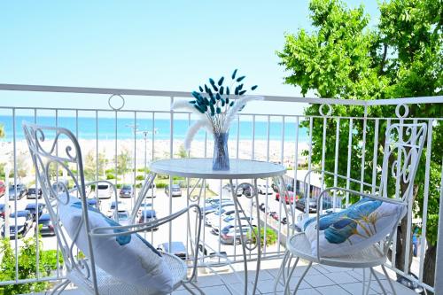 a table and chairs on a balcony with a view of the ocean at Hotel B&B Nizza Riccione in Riccione