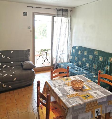 un salon avec une table et un canapé dans l'établissement CAP D'AGDE Studio 3 personnes Résidence Sentosa B22 quartier môle, au Cap d'Agde