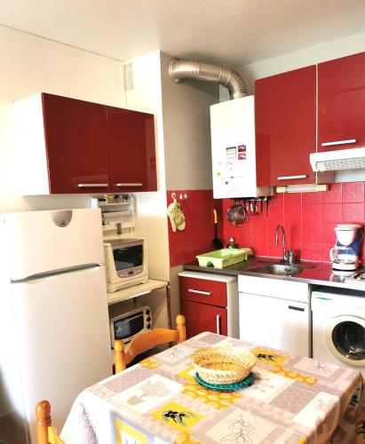 une cuisine avec une table et un réfrigérateur blanc dans l'établissement CAP D'AGDE Studio 3 personnes Résidence Sentosa B22 quartier môle, au Cap d'Agde