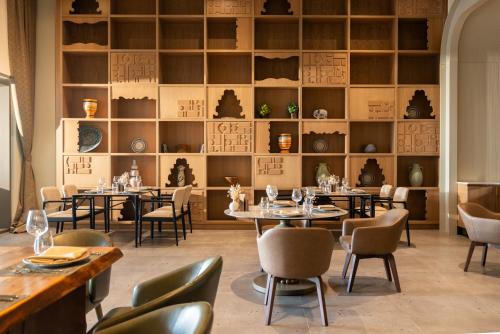 a dining room with tables and chairs and shelves at Ethno Belek in Belek
