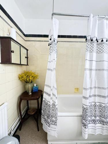 a bathroom with a bath tub with a shower curtain at The Eastbrook Pub & Hotel in Dagenham