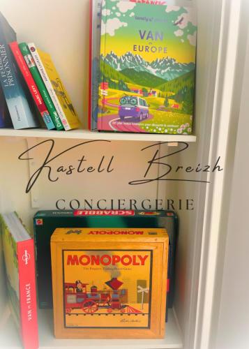 a book shelf filled with books and a monopoly game at Town House in Guingamp