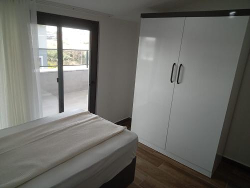 a bedroom with a bed and a white cabinet at Villa Tosun in Belek