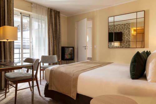 a hotel room with a bed and a table and a desk at Jardins Eiffel in Paris