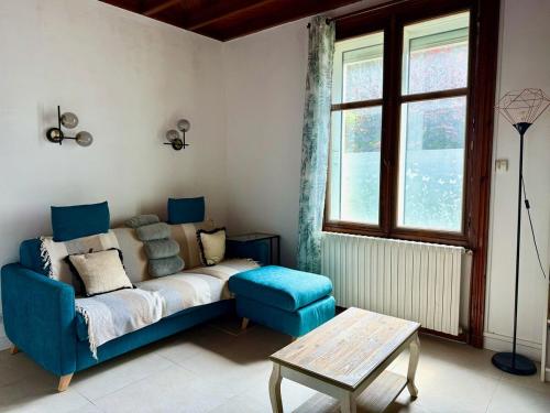 a living room with a blue couch and a table at Les Lutins Villa Le Pouliguen in Le Pouliguen