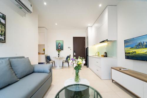 a living room with a couch and a table at Novus Sol Hotel & Apartment Sunset Town Phu Quoc in Phu Quoc