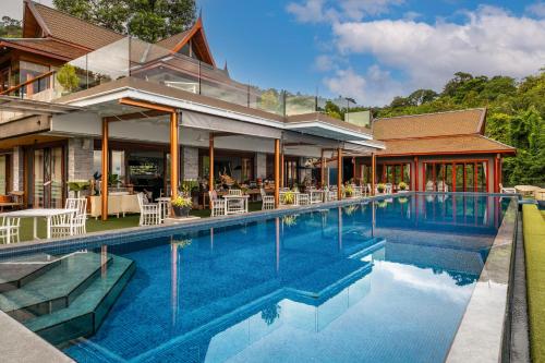 a swimming pool in front of a house at Ayara Kamala Resort & Spa - SHA Extra Plus in Kamala Beach