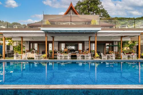 a pool at a hotel with chairs and tables at Ayara Kamala Resort & Spa - SHA Extra Plus in Kamala Beach