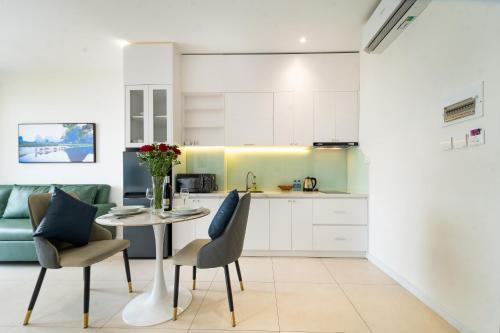 a kitchen and dining room with a table and chairs at Novus Sol Hotel & Apartment Sunset Town Phu Quoc in Phu Quoc