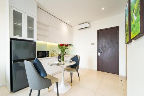 a kitchen and dining room with a table and chairs at Novus Sol Hotel & Apartment Sunset Town Phu Quoc in Phu Quoc