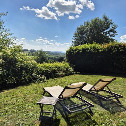 deux chaises de jardin et une table sur un terrain dans l'établissement Le Mas de Rigoulac 5 Chambres d'hotes & SPA sur réservation table d hôtes sauf les mercredis et les dimanches, à Bouyssounouse