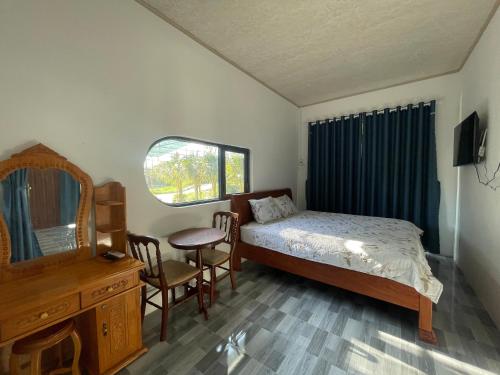 Un dormitorio con una cama, una cómoda y un espejo. en TUTA House, en Cam Lâm