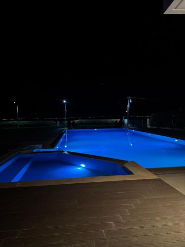 a large blue swimming pool at night at Villa Al mare Stav in Kouvéla