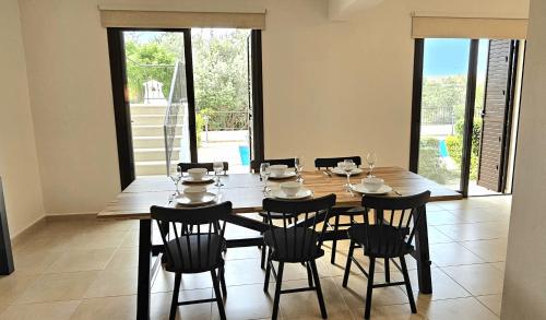 a dining room with a wooden table and chairs at Hillside Azure in Polis Chrysochous