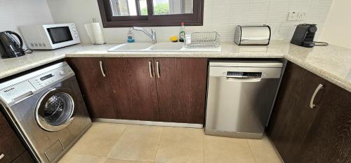a kitchen with a sink and a washing machine at Hillside Azure in Polis Chrysochous