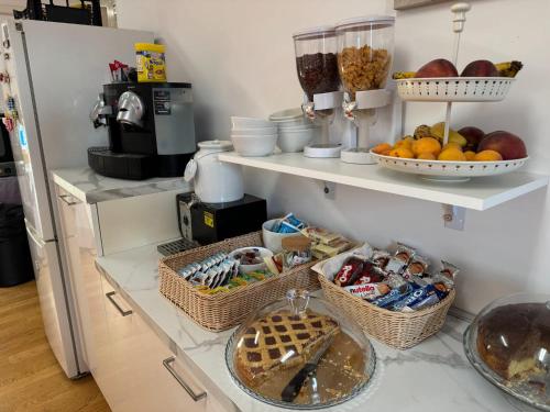 ロレートにあるResidenza Antiche Muraの棚に食べ物や果物の入ったバスケットが置かれたキッチン