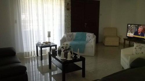 a living room with a couch and a tv at Nikola's House in Limassol