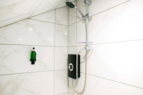 una ducha con cabezal de ducha en un baño en Nestee Serviced Apartments - Central Torquay - Pet Friendly - Harbour Views, en Torquay